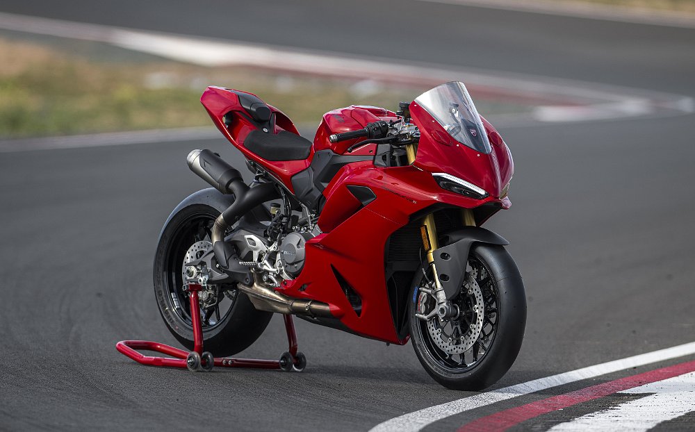2025 Ducati Panigale V2 seen from the right, parked on a rear stand on a race track.