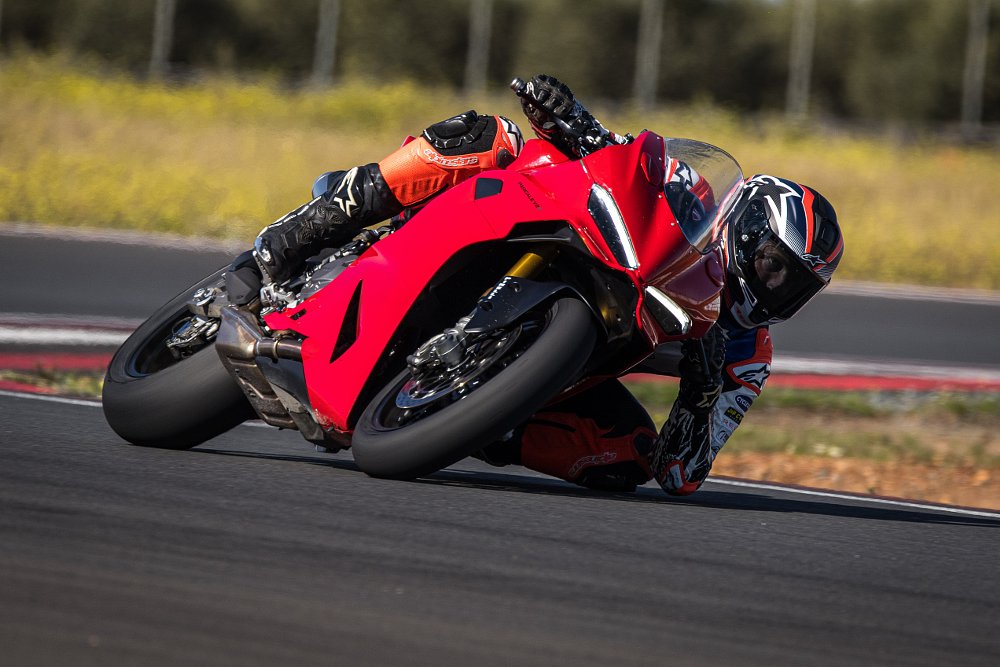 2025 Ducati Panigale V2 leaning left through a curve on a race track.