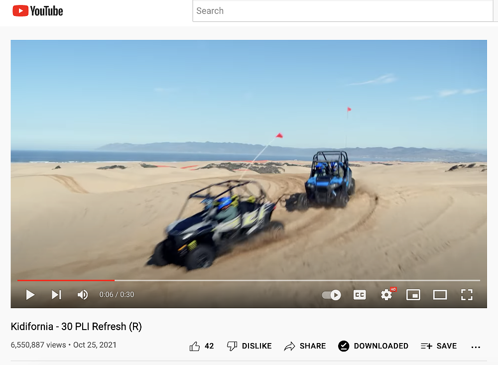 A screenshot of a youtube video featuring the CA board of tourism video at Pismo Beach in which two side by side OHVs are in the sand