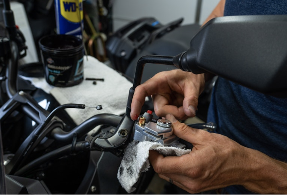 Lubricating the clutch lever pivot on a motorcycle.