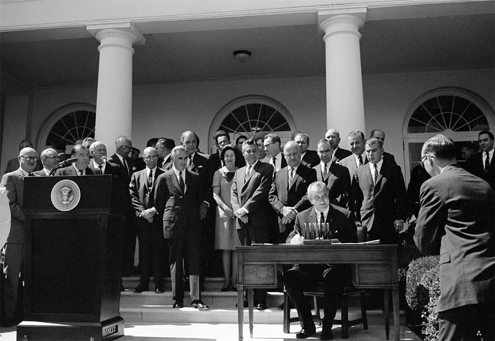 A black and white photo of President Johnson signing the safety act into law in 1966
