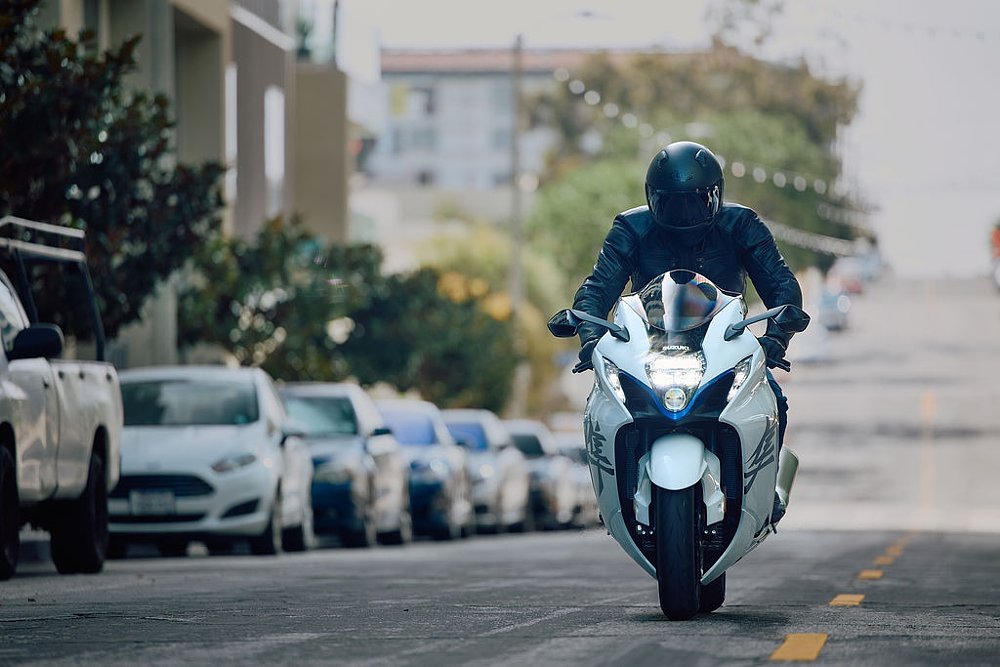 2023 Suzuki Hayabusa riding toward camera down a city street.