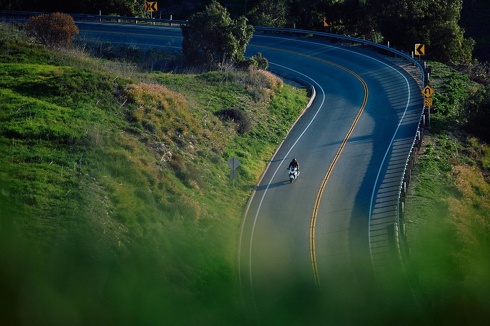 2023 Suzuki Hayabusa alone on a mountain road in the distance, riding toward camera.