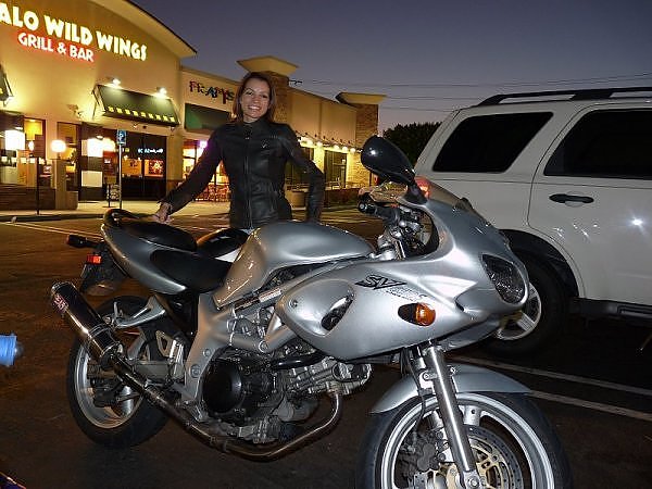 A photo at night parking lot on a silver 2002 suzuki sv650 s