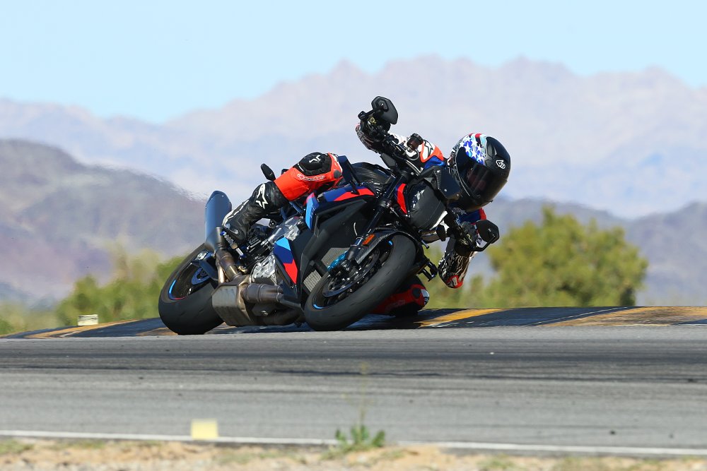 2023 BMW M 1000 R turning through a left-hand corner on a racetrack.