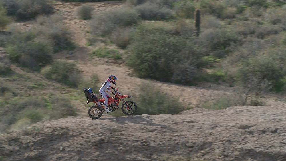 motorcycle on a desert trail with a baby figure in a car seat