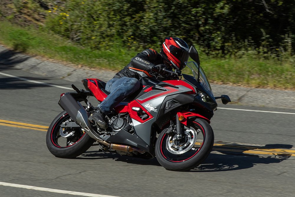riding a red version of the Ninja 500 on a curvy road