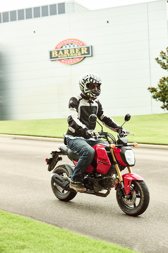 riding a Grom past the Barber Motorsports Museum sign