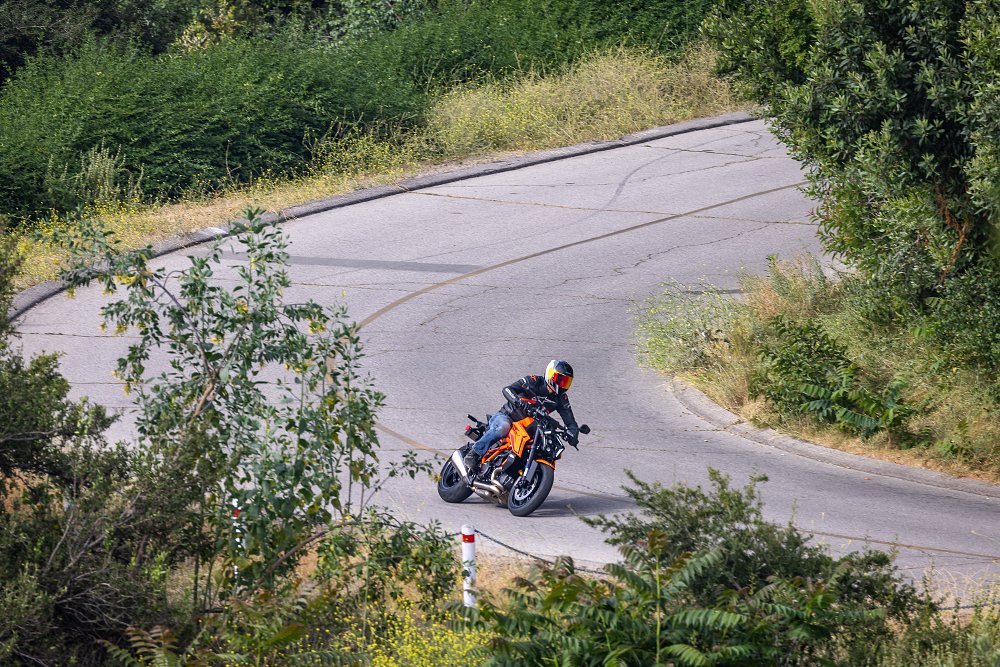 Faraway photo of a KTM 1390 Super Duke R riding along a narrow mountain road.