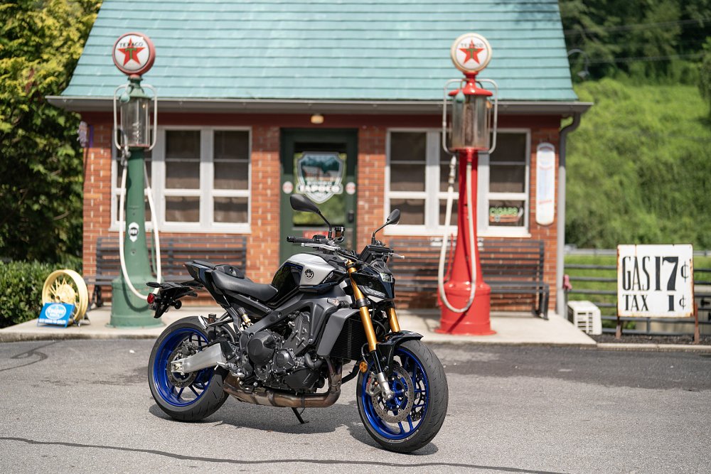 Yamaha MT-09 SP parked in front of an old gas station with antique pumps