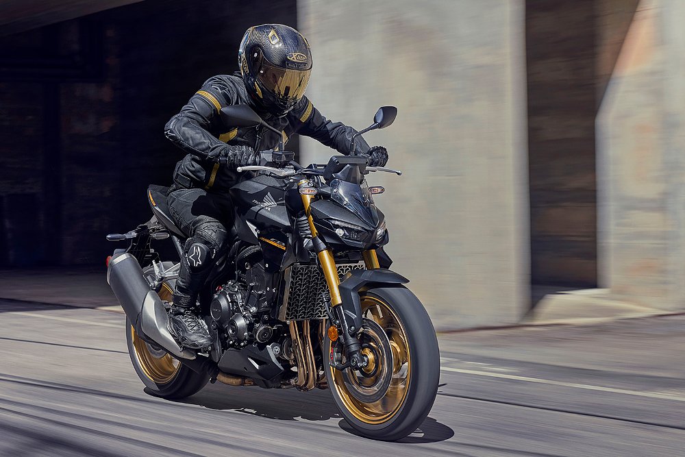 A ride, clad in black and gold, piloting the CB1000 Hornet SP down the street.