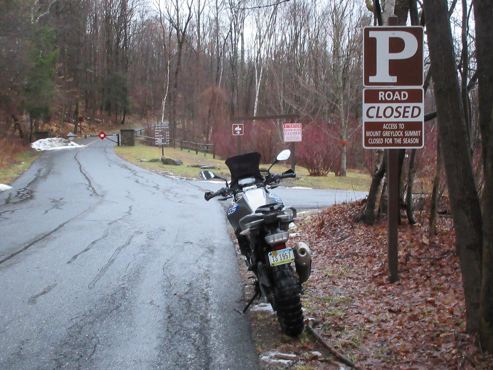 BMW parked beside a 'road closed' sign in winter