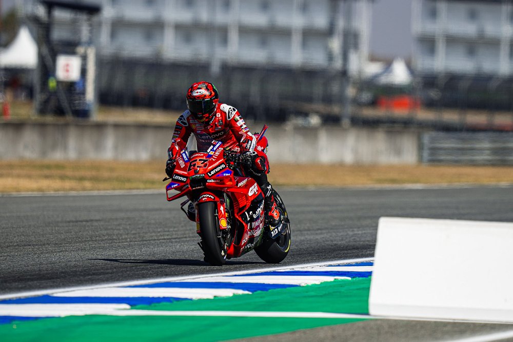 Pecco Bagnaia on his red Ducati MotoGP race motorcycle braking hard for a turn